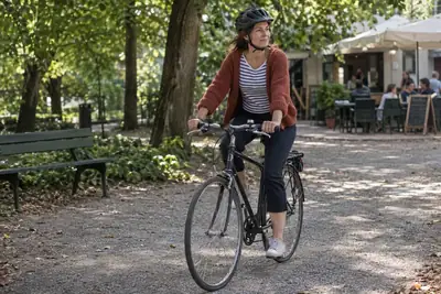 Fahrerin auf einem Fahrrad ohne Motor bei einer Tour durch einen Stadtpark